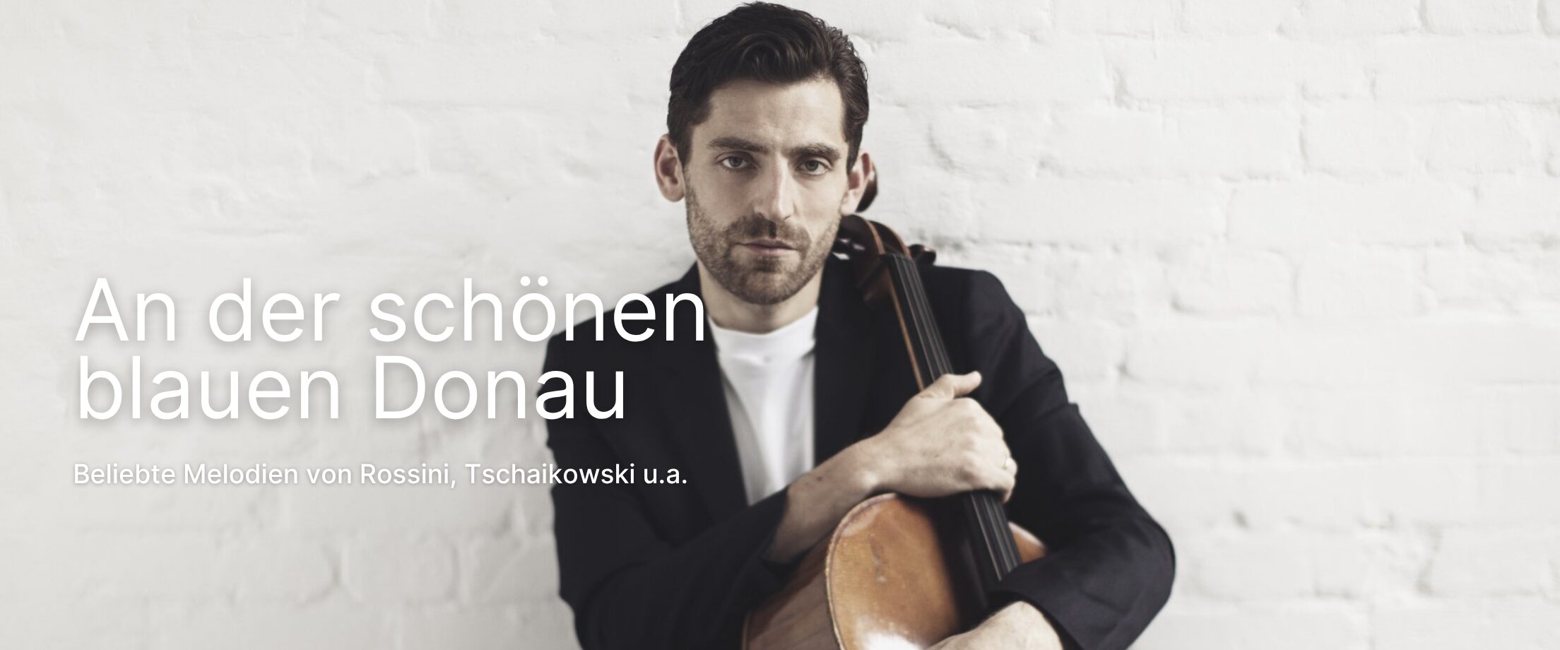 Arthur Hornig mit Cello im Arm vor weißer Wand