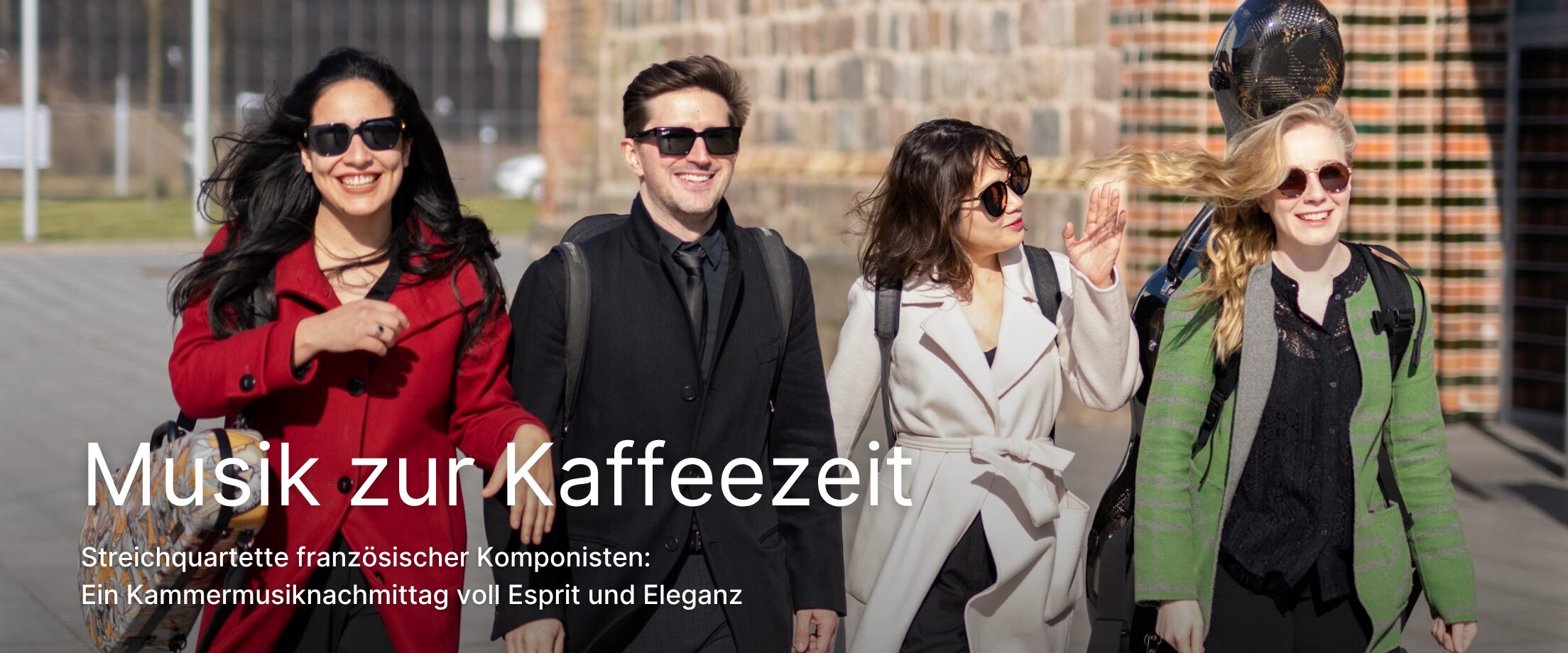 4 Musiker gehen in einer Reihe vor der Konzertkirche Neubrandenburg entlang